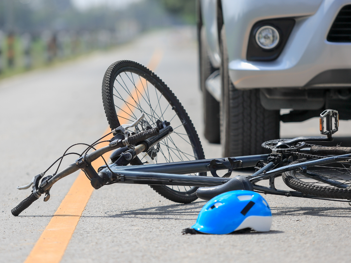 A bicycle on the road next to a car.